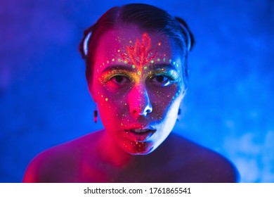 Body art on woman glowing in ultraviolet light. Art and sensuality concept with neon lighting.