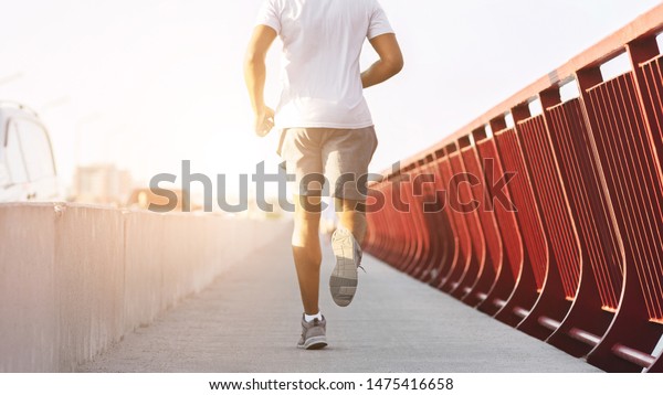 Body Of Athletic Black Guy Running On Bridge In Sun\
Flare, copy space