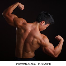 Body Builder Posing With His Back Muscles On Black Background