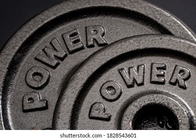 Body Building, Muscle Hypertrophy Through Strength Training And Exercising Equipment Concept With Close Up On Gym Weight Disc With The Text Power