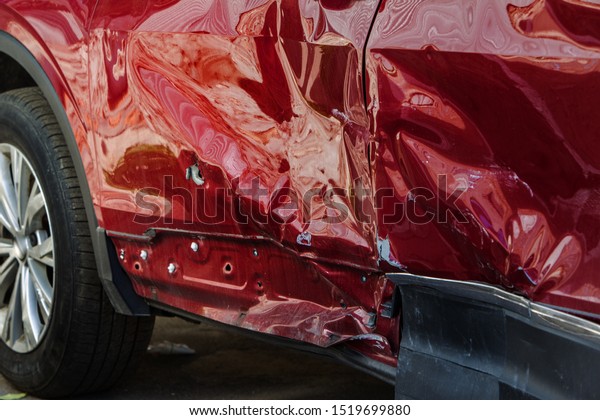 The body of the car is damaged
as a result of an accident. High speed head on a car  traffic
accident. Dents on the car body after a collision on the
highway