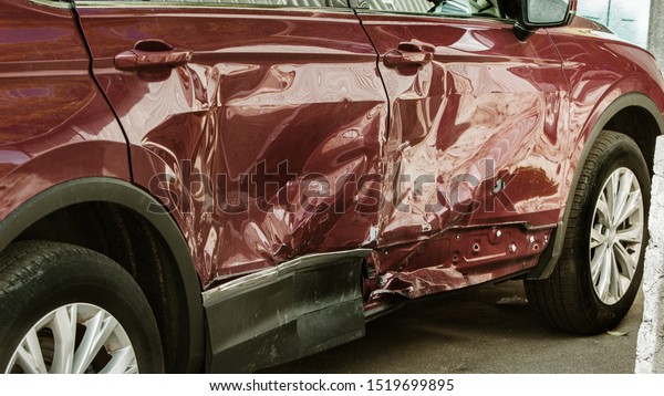 The body of the car is damaged\
as a result of an accident. High speed head on a car  traffic\
accident. Dents on the car body after a collision on the\
highway