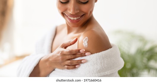 Body Care. African American Woman Applying Lotion On Shoulders Moisturizing Skin After Shower In Modern Bathroom Indoors. Beauty And Skincare Concept. Panorama, Cropped