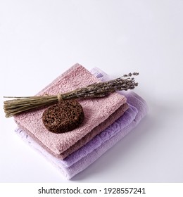 Body Care Kit. Soft, Cotton Towels, Purple Shades, Lavender And Foot Peeling On A Light Background, Selective Focus