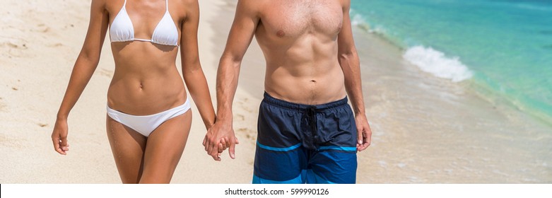 Body care sexy people in swimwear on beach banner background. Couple holding hands, woman in bikini, man in swim trunks showing toned abs stomach for healthy fitness concept.