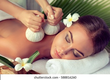 Body care. Spa body massage treatment with hot  herbal ball for deep relaxation . Woman having massage in the spa salon 