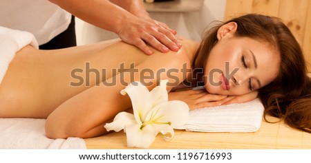 Body care. Spa body massage treatment. Woman having massage in the spa salon. Beb banner dimension image ofmasseur massaging young woman back