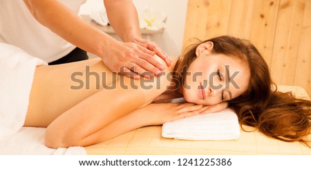 Body care. Spa body massage treatment. Woman having massage in the spa salon. Beb banner dimension image ofmasseur massaging young woman back