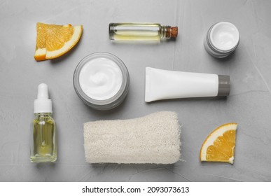 Body Cream And Other Cosmetic Products With Orange On Light Grey Table, Flat Lay