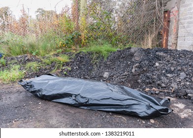 A Body Inside A Body Bag At An Isolated Location.