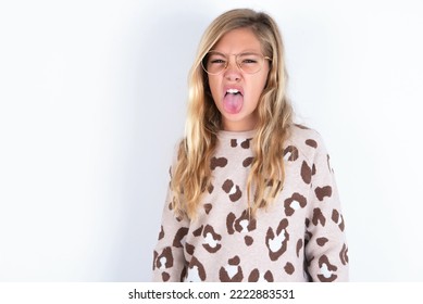 Body Language. Disgusted Stressed Out Caucasian Teen Girl Wearing Animal Print Sweater Over White Wall , Frowning Face, Demonstrating Aversion To Something.