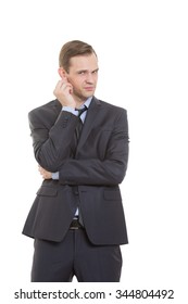 Body Language. Man In Business Suit Isolated White Background. Scratching, Rubbing The Ear. Gesture Of Distrust Speaker