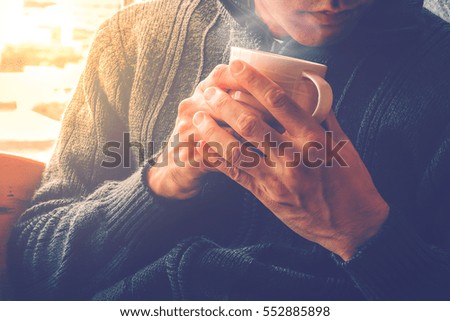 Body of a man holding a cup of coffee in winter season