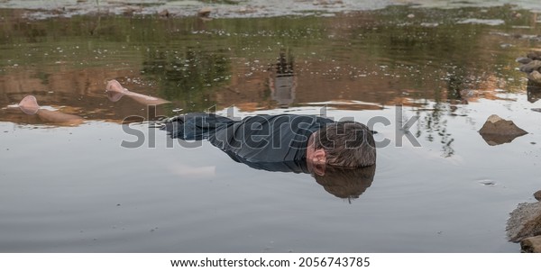 the body
of a man who drowned, lying face down in the water lifeless body.
artistic photo painting, selective focus
,