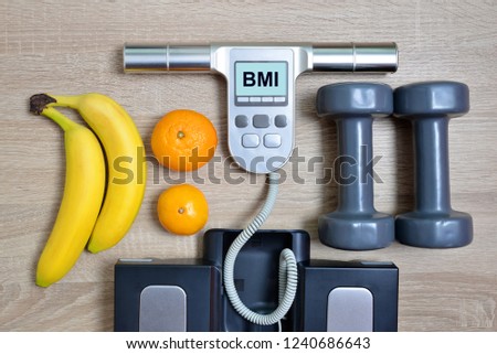  Body Mass Index Scale with fruits and dumbbells on wooden board.Healthy lifestyle concept.