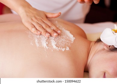 Body massage with marine salt in a spa to exfoliate the skin and replace energising minerals - Powered by Shutterstock