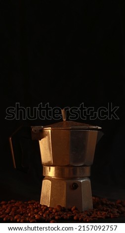 Body moka pot with coffee beans at the bottom has warm lighting         