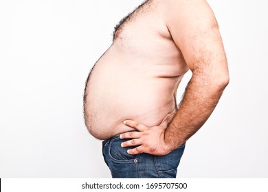 Body Part Of Asian Fat Man With A Big Hairy Belly. Overweight Man Closeup Of Belly Side View - Man Touching His Fat Belly - Fat Man & Diet, Belly Fat. Isolated On White Background. Unhealthy Lifestyle