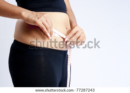 Body part of a fat woman with measuring tape