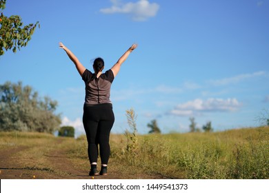 Body Positive, Confidence, High Self Esteem, Free Your Mind Concept. Overweight Woman Rising Hands Towards The Sky, View From The Back