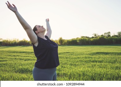 Body positive, freedom, high self esteem, confidence, happiness, success, positive affirmation,  inspiration, meditation Overweight woman practicing yoga on meadow