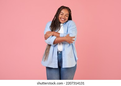 Body Positive. Happy African American Overweight Female Hugging Herself Posing With Eyes Closed, Wearing Plus Size Clothes Standing Over Pink Studio Background. Self Love Concept - Shutterstock ID 2207314131