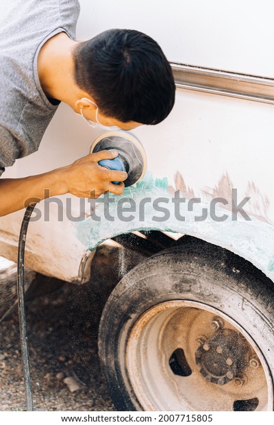 body repair, a man
with tools repairs a car