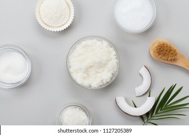 Body scrub of coconut oil, sugar and shavings in glass jar top view. Homemade cosmetic for peeling and spa care. Flat lay.