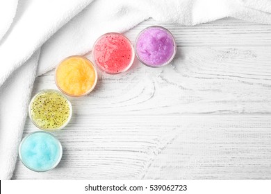 Body scrubs on wooden background