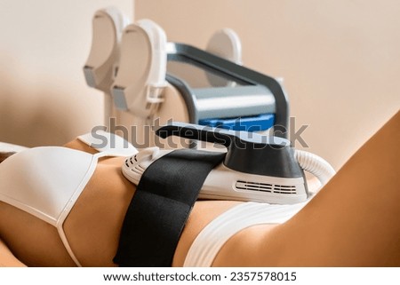 A body sculpting treatment of stomach for young woman in a beauty salon. Body care concept. 