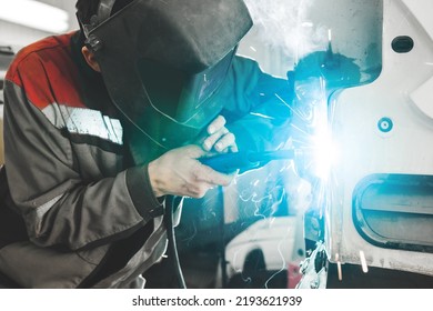 Body Shop Worker Welding Car Body. Work With Carbon Dioxide Weld.