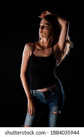 Body Shot Of A Stylish Woman Posing In Trendy Ripped Jeans And Black Tank Top