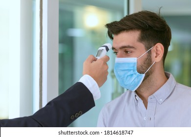 Body temperature check, Receptionist and guest wearing face mask at front desk  at hotel. Covid 19 and coronavirus infection protection and protective policy concept  - Powered by Shutterstock