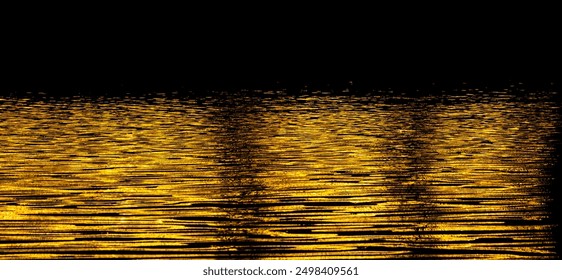 A body of water with a golden hue, creating a serene and peaceful atmosphere. The water appears to be calm and still, with ripples and waves gently lapping against the shore - Powered by Shutterstock