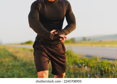 The body of a young athlete running and checking the time on the smart watch on his hand. - Shutterstock ID 2245708905