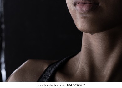 Body Of Young Fitness Woman Who Has Hot Sweat From Exercise, Sweaty On Neck Chest Chin Part. Low Exposure Dark Background Copy Space