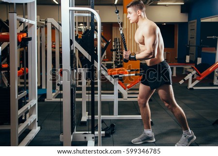 Bodybuilder Doing Heavy Weight Exercise For Triceps With Cable in the gym