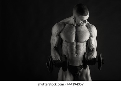 Bodybuilder posing in different poses demonstrating their muscles. Failure on a dark background. Male showing muscles straining. Beautiful muscular body athlete. - Shutterstock ID 444194359