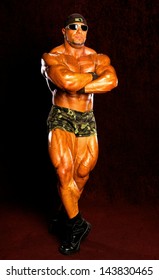 Bodybuilder posing on a dark background - Shutterstock ID 143830465