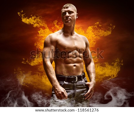 Bodybuilder posing on the fire flames background