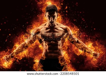 Bodybuilder posing on the fire flames background. High quality photo