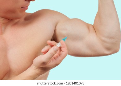 Bodybuilder Taking Steroids Injection In Arm On Blue Background. 
