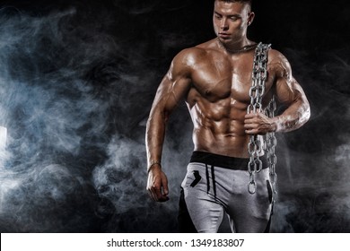 Bodybuilding Competitions On The Scene. Man Sportsmen Physique And Athlete. Black Background With Lights.