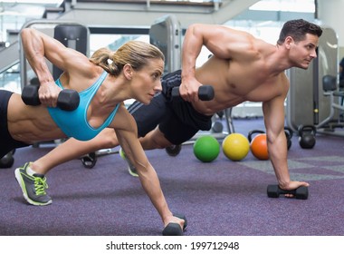 Bodybuilding Man And Woman Holding Dumbbells In Plank Position At The Gym