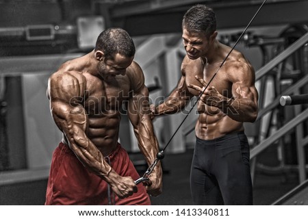 Bodybuilding Motivation. Two Bodybuilders Train Together at the Gym