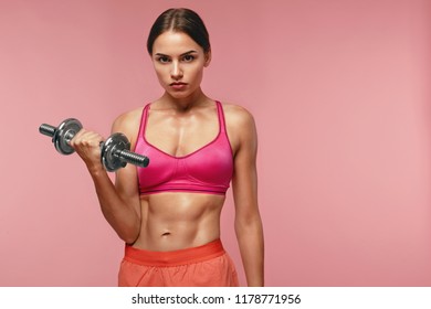 Bodybuilding. Woman Training With Dumbbell On Pink Background