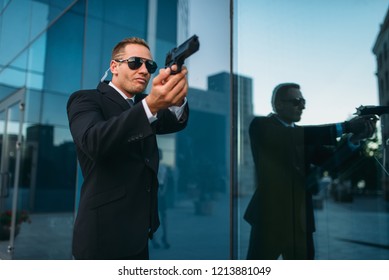 Bodyguard With Security Earpiece And Gun In Hands