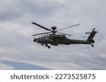 A Boeing AH-64 (Apache) midair with one airman doing the horn. 