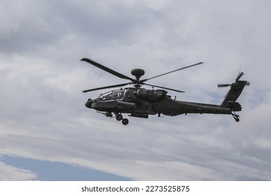 A Boeing AH-64 (Apache) midair with one airman doing the horn. 
