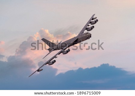 Boeing B52 Bomber of the United `states Airforce (USAF) at sunset. B-52 nuclear and heavy bomber banking towards the camera at sunset. New engine contract from Rolls Royce